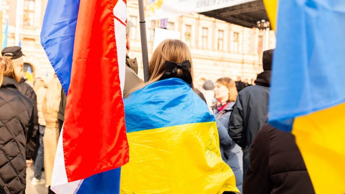A peaceful protest in Zagreb, Croatia with participants holding Ukrainian flags, showing support and unity.