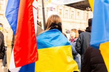 A peaceful protest in Zagreb, Croatia with participants holding Ukrainian flags, showing support and unity.