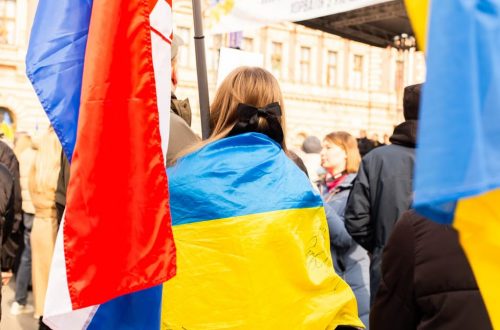 A peaceful protest in Zagreb, Croatia with participants holding Ukrainian flags, showing support and unity.